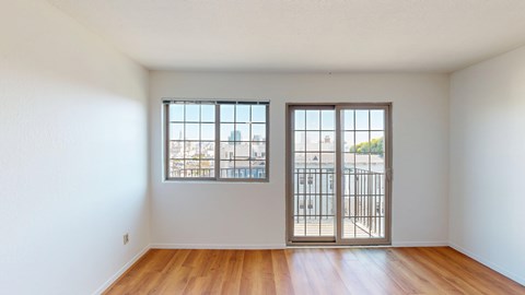 A room with a sliding door and a window overlooking a cityscape.