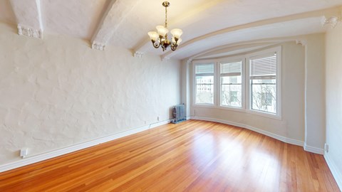 A room with wooden floors and a chandelier.