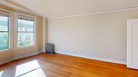 A room with a wooden floor and a white door.