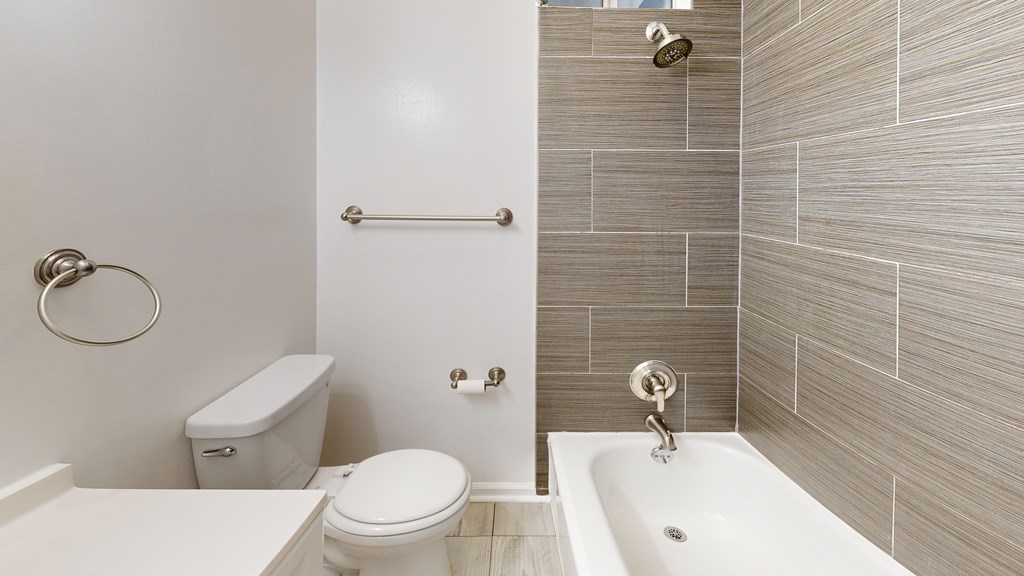 A white toilet sits next to a white sink in a bathroom.