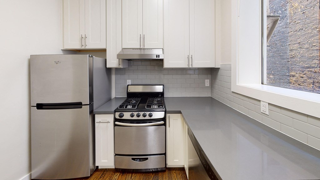 a kitchen with white cabinets and a stainless steel refrigerator