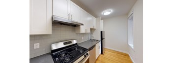 a kitchen with white cabinets and a stove