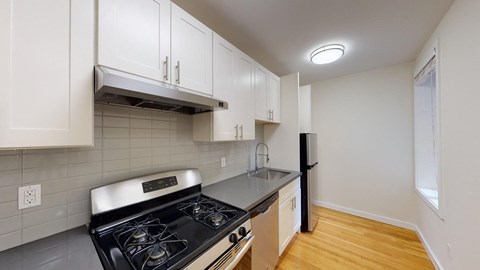 a kitchen with white cabinets and a stove