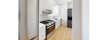 a kitchen with white cabinets and stainless steel appliances