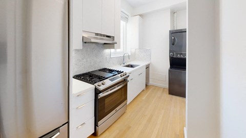a kitchen with white cabinets and stainless steel appliances