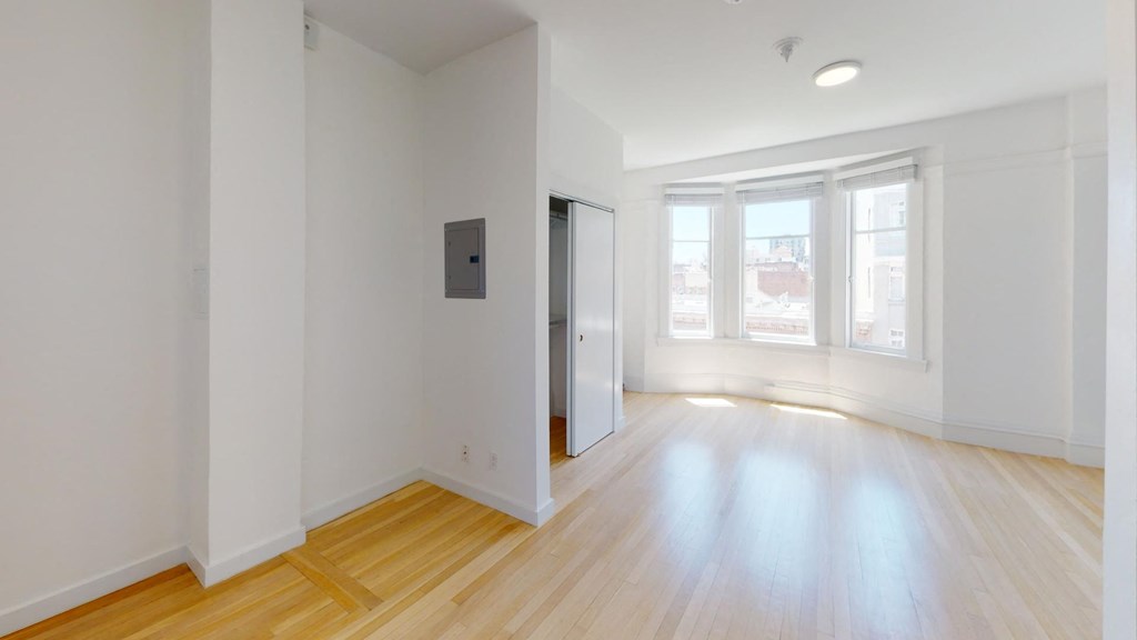 a living room with a hard wood floor and white walls