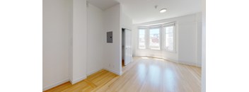 a living room with a hard wood floor and white walls
