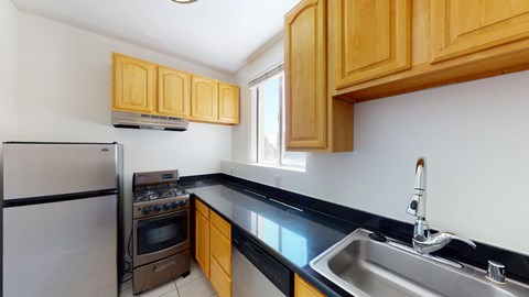 A kitchen with wooden cabinets and a stainless steel sink.
