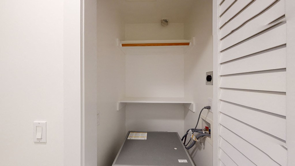 the laundry room has a sink and a shelf in it