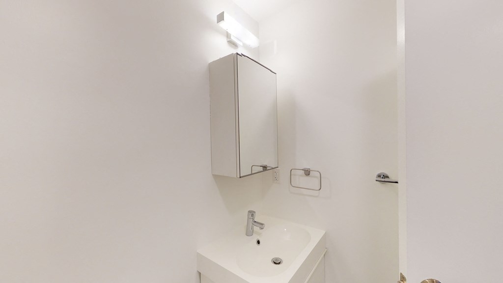 a white bathroom with a sink and a mirror