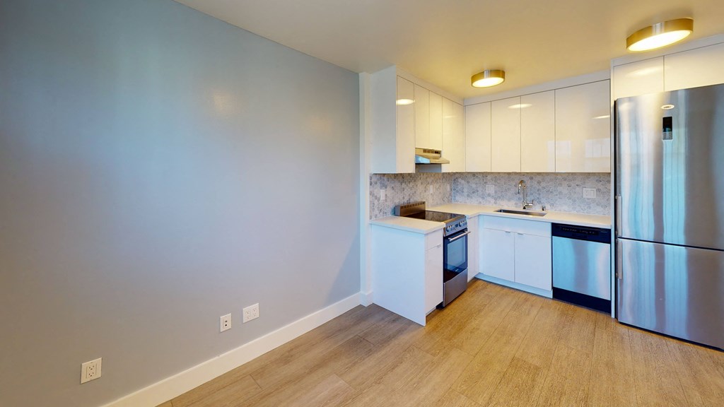a kitchen with white cabinets and a stainless steel refrigerator