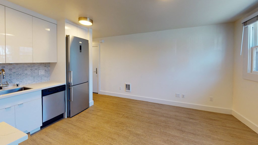 a kitchen with white cabinets and a stainless steel refrigerator
