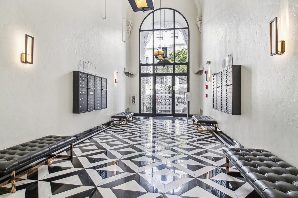 Lobby with a high, arched doorway and large glass panels allow natural light to brighten the space, wall-mounted mailboxes