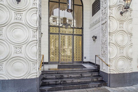 A white building with a large golden door.