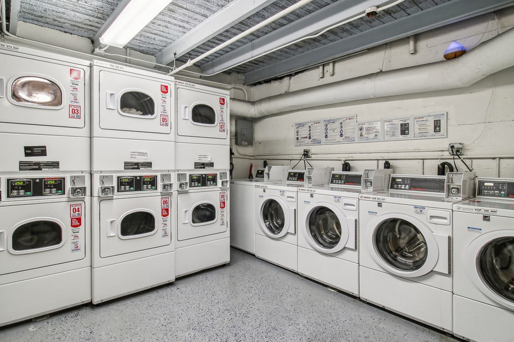 Laundry room with a row of washing machines and dryers