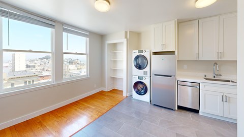 A kitchen with a refrigerator, dishwasher and washing machine.