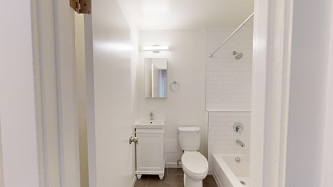 A white bathroom with a toilet, sink, and bathtub.