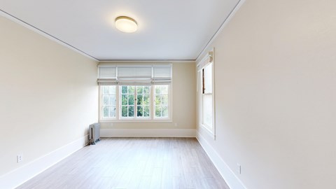 A room with a window and a radiator on the floor.