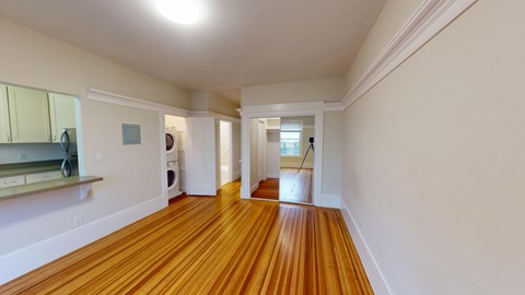 A long hallway with wood floors and white walls.