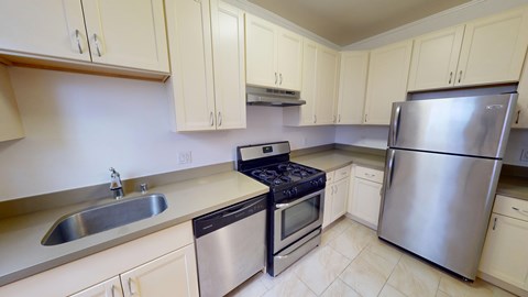 A kitchen with a stove, sink, and refrigerator.