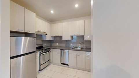 A kitchen with white cabinets and stainless steel appliances.