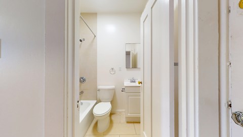 A white bathroom with a toilet, sink, and bathtub.