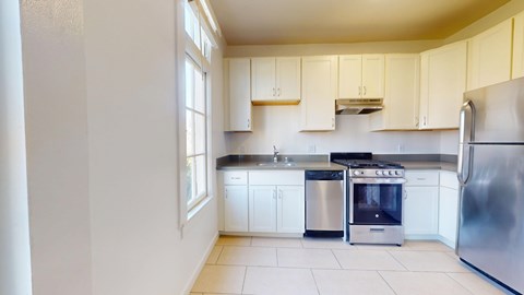 A kitchen with white cabinets and stainless steel appliances.