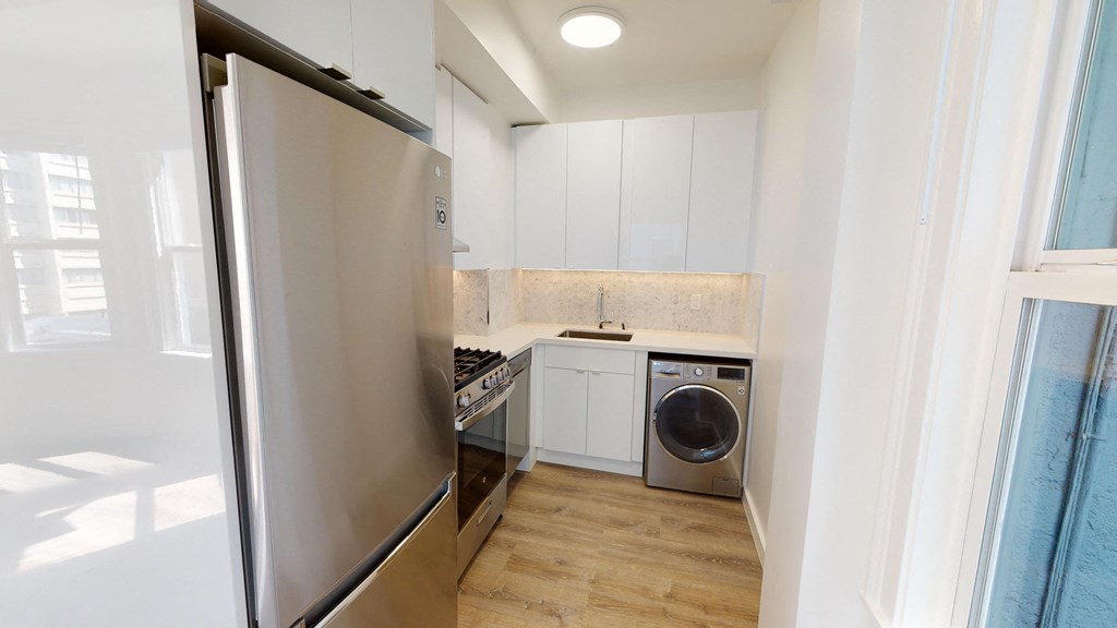 a small kitchen with a refrigerator and a washing machine