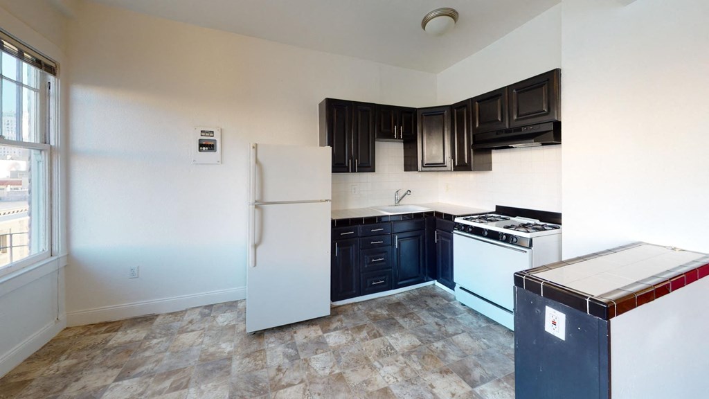 an empty kitchen with white appliances and black cabinets