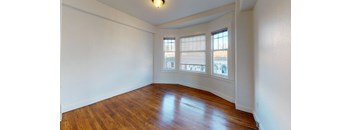 the living room of an empty house with wood floors and windows