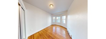an empty living room with white walls and wood floors