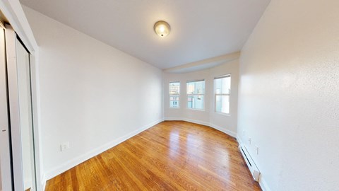 an empty living room with white walls and wood floors