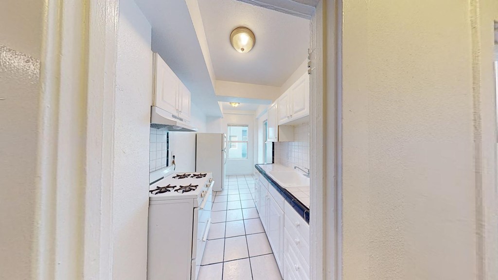 a kitchen with white cabinets and a stove and a refrigerator
