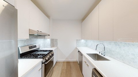 a kitchen with white cabinets and stainless steel appliances