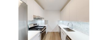 a kitchen with white cabinets and stainless steel appliances