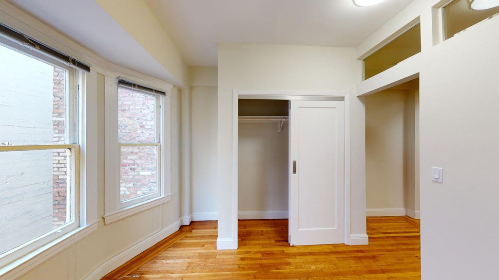 an empty room with a closet and a window