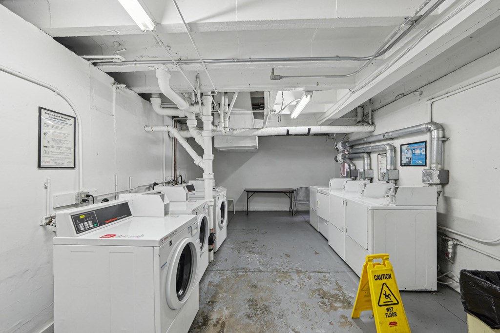 Laundry room with a row of washing machines and dryers
