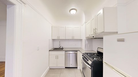 A kitchen with white cabinets and a black stove top.
