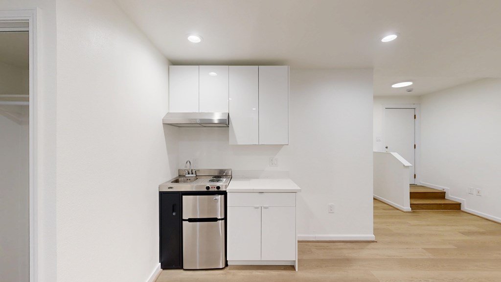 A kitchen with white cabinets and a stainless steel dishwasher.