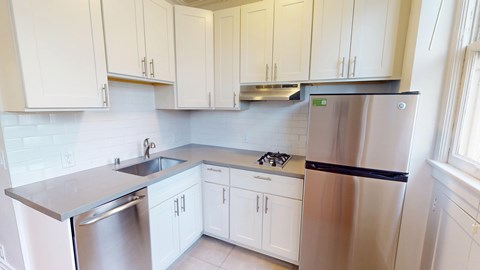 A kitchen with white cabinets and stainless steel appliances.