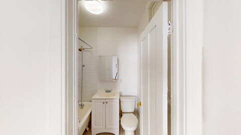 A white bathroom with a toilet, sink, and bathtub.