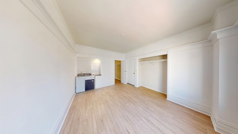 A room with a white wall and a wooden floor.