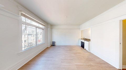 A large empty room with a window overlooking a cityscape.