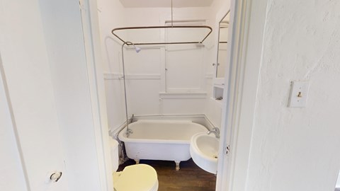 A white bathroom with a toilet, sink, and bathtub.