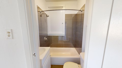 A white bathroom with a toilet, sink, and shower.