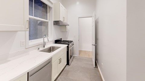A kitchen with white cabinets and a black dishwasher.
