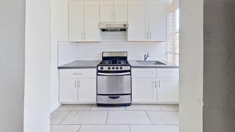 A modern kitchen with a stove and cabinets.