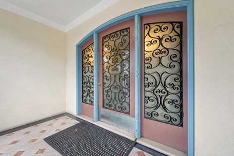 A set of decorative metal doors with a mat in front of them.