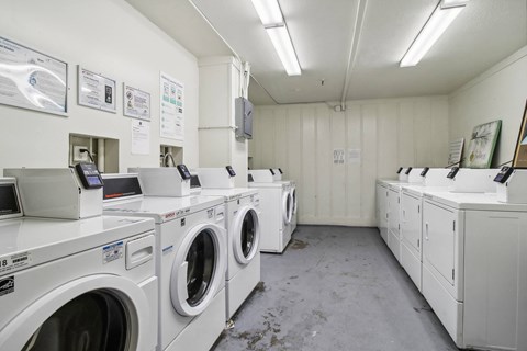 Laundry room with washing machines neatly arranged on a wooden floor