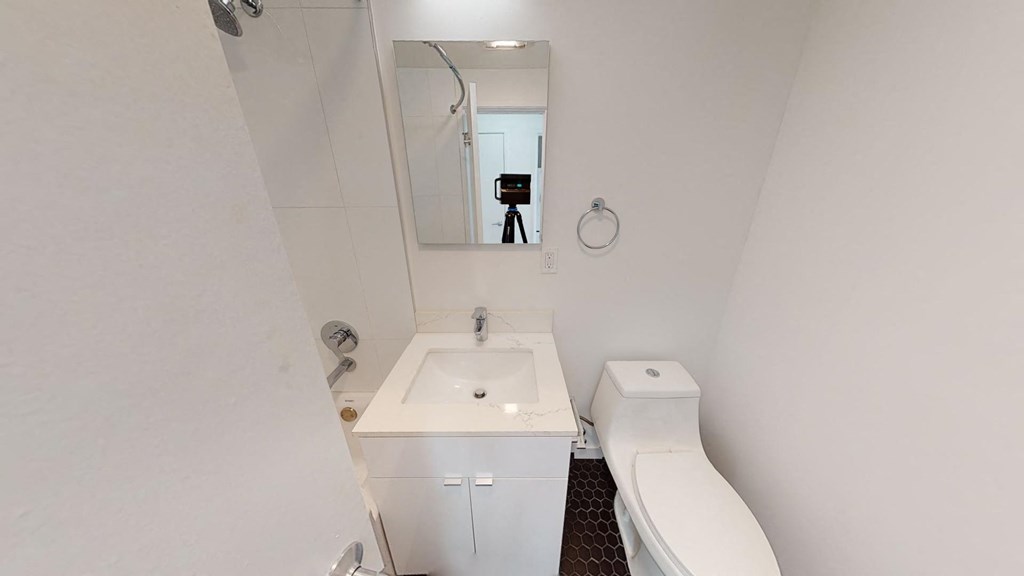 a white bathroom with a sink toilet and a mirror